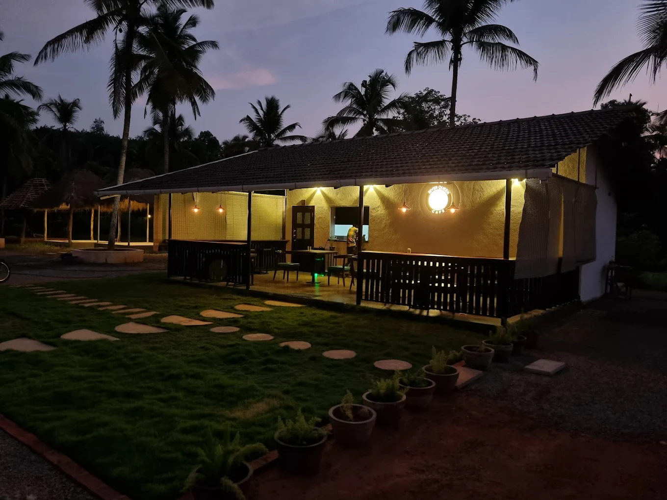 River Queen lakeside cafe in Shantimogar, Puttur with garden seating and evening ambience – one of the best cafes in Puttur